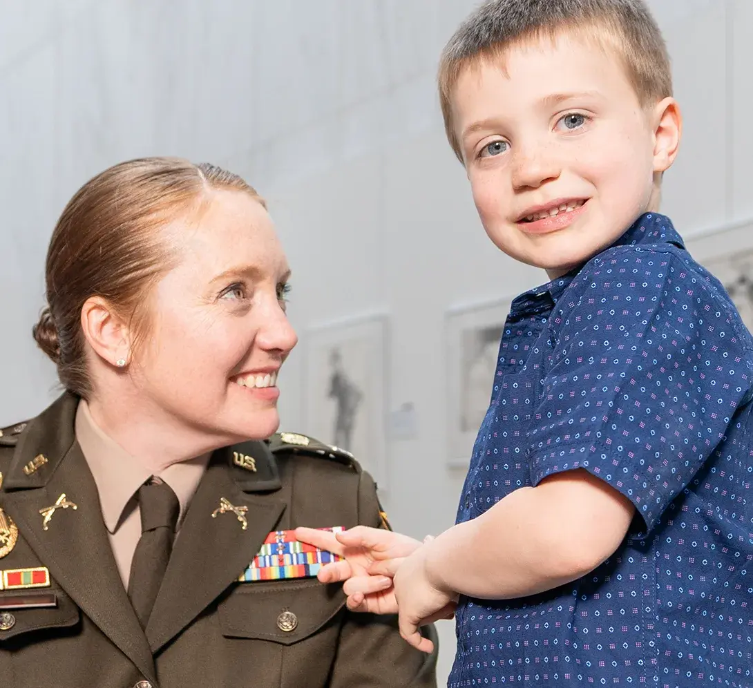 Woman smiling staring at a kid staring to the camera
