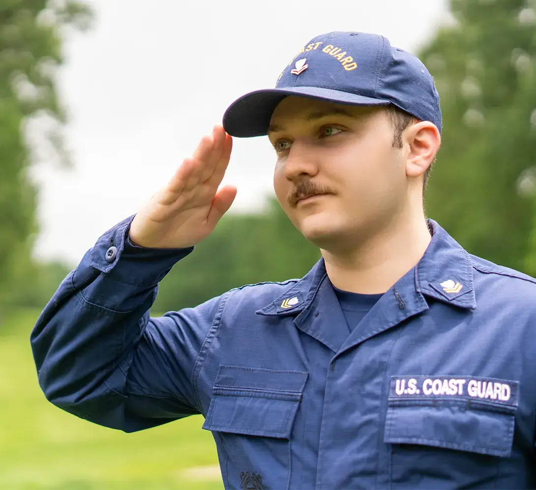 A person in U.S. Coast Guard uniform giving a salute.