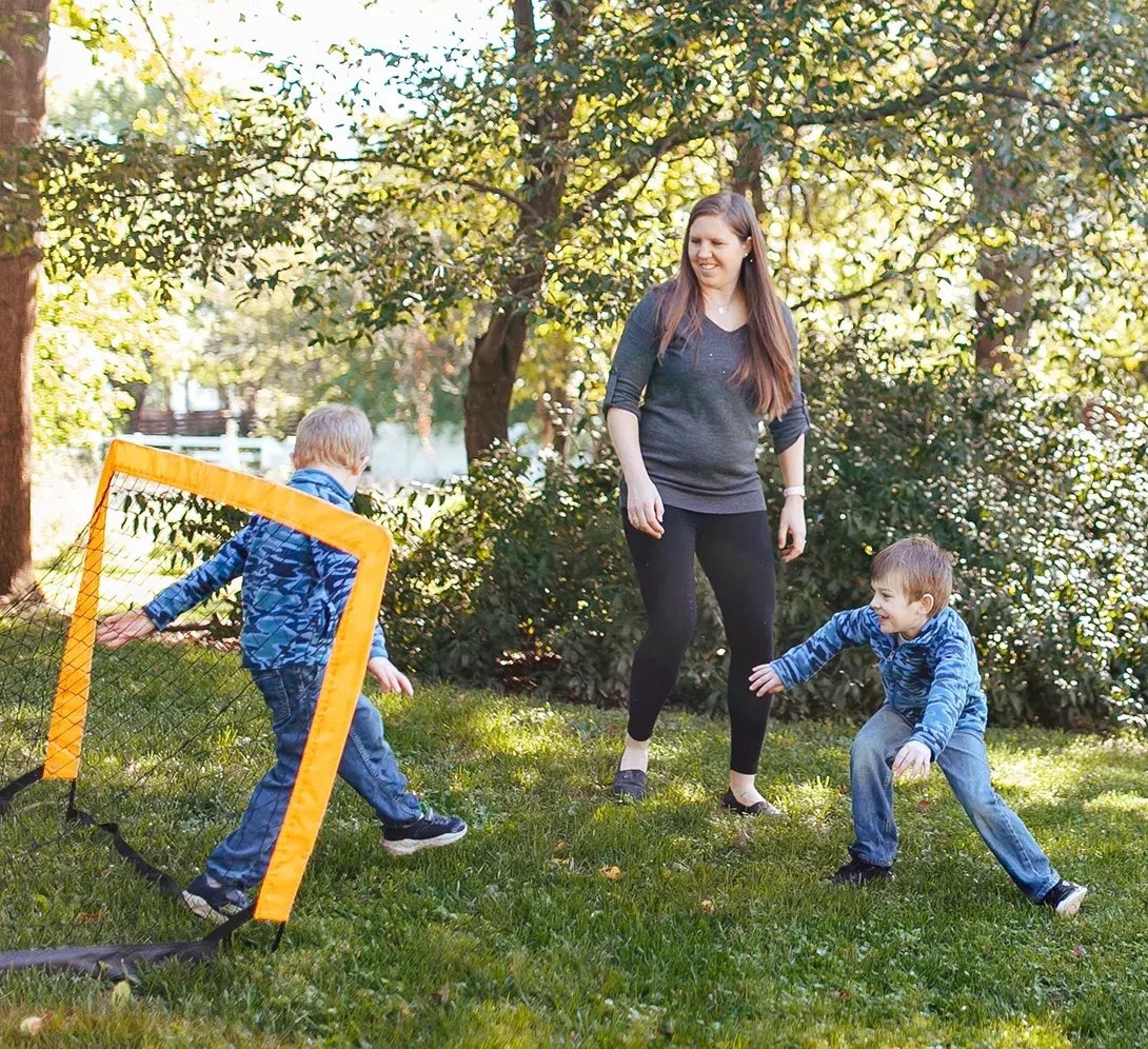 A mother playing outside with her children.