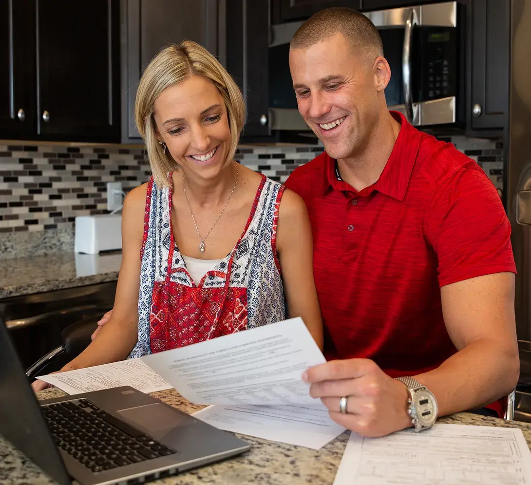 Couple reviewing papers in the kitchen.