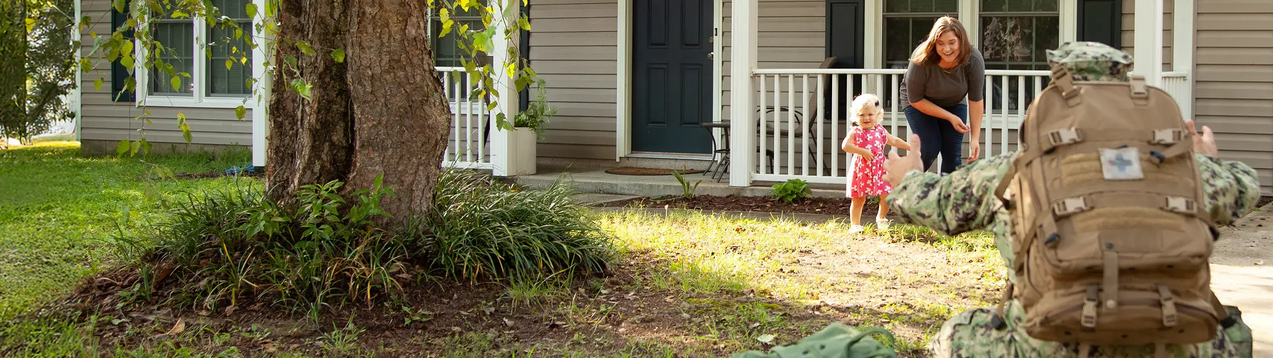 A military families reunion in front of a house.