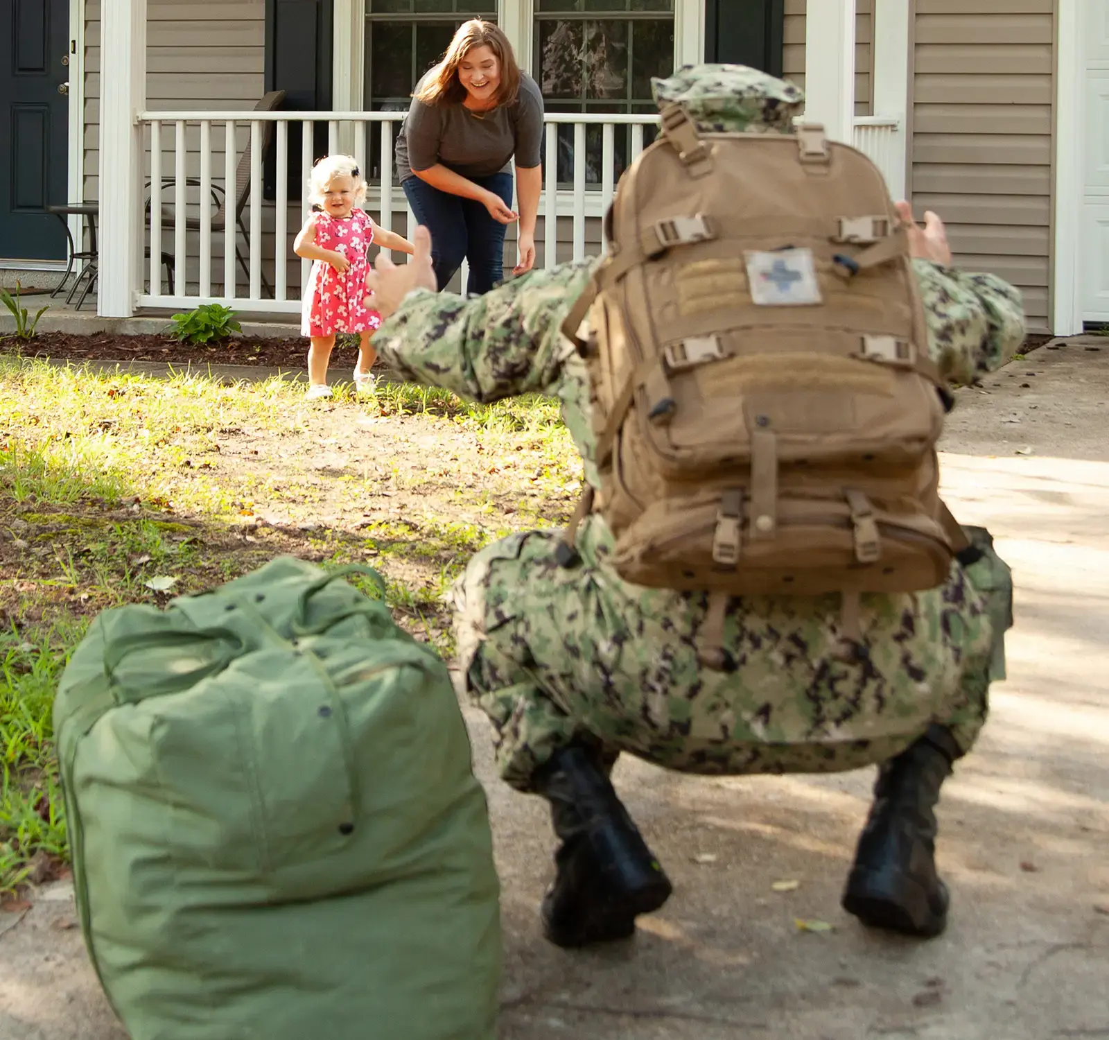 A family greeting each other outside of a house.
