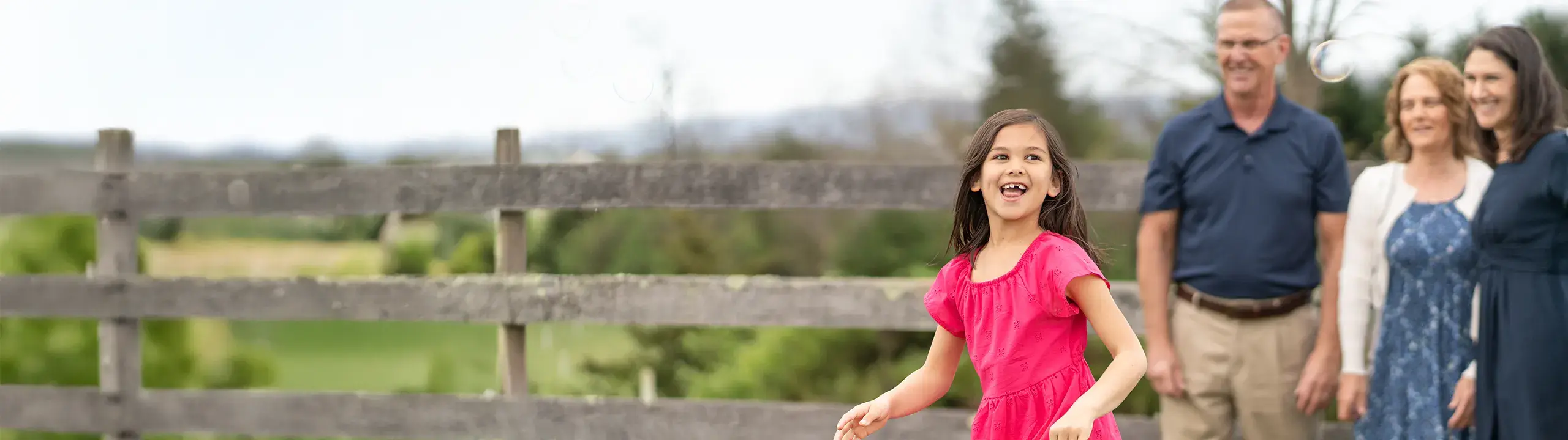Image of three adults watching a child play.