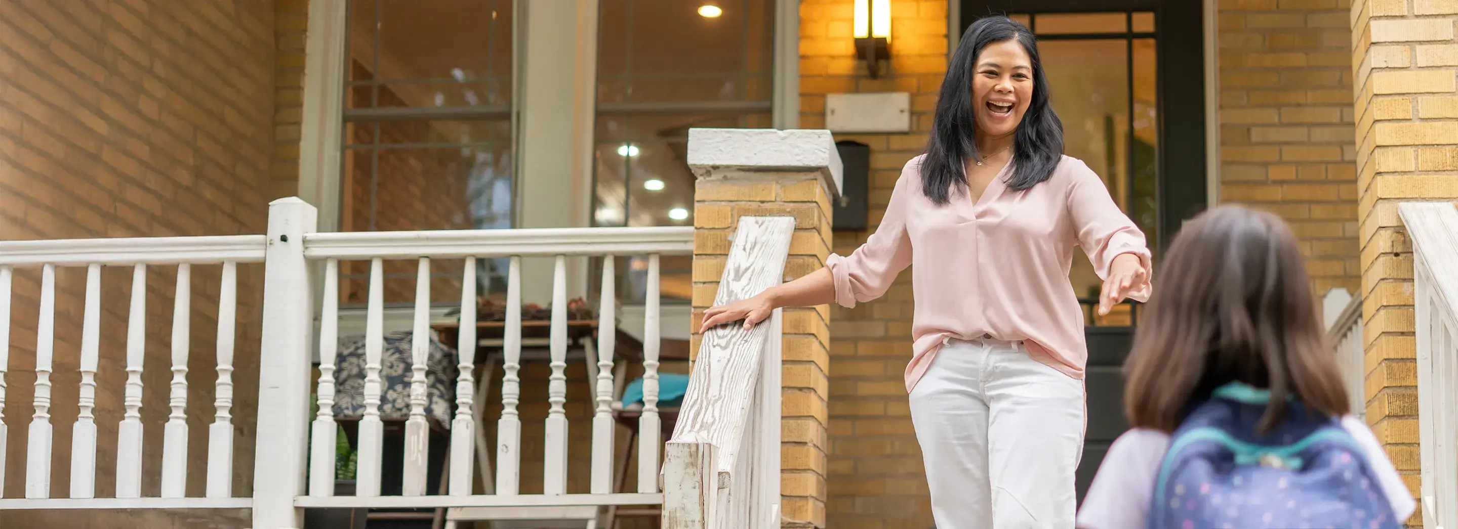 Mom walking down the steps of the porch meeting their child.
