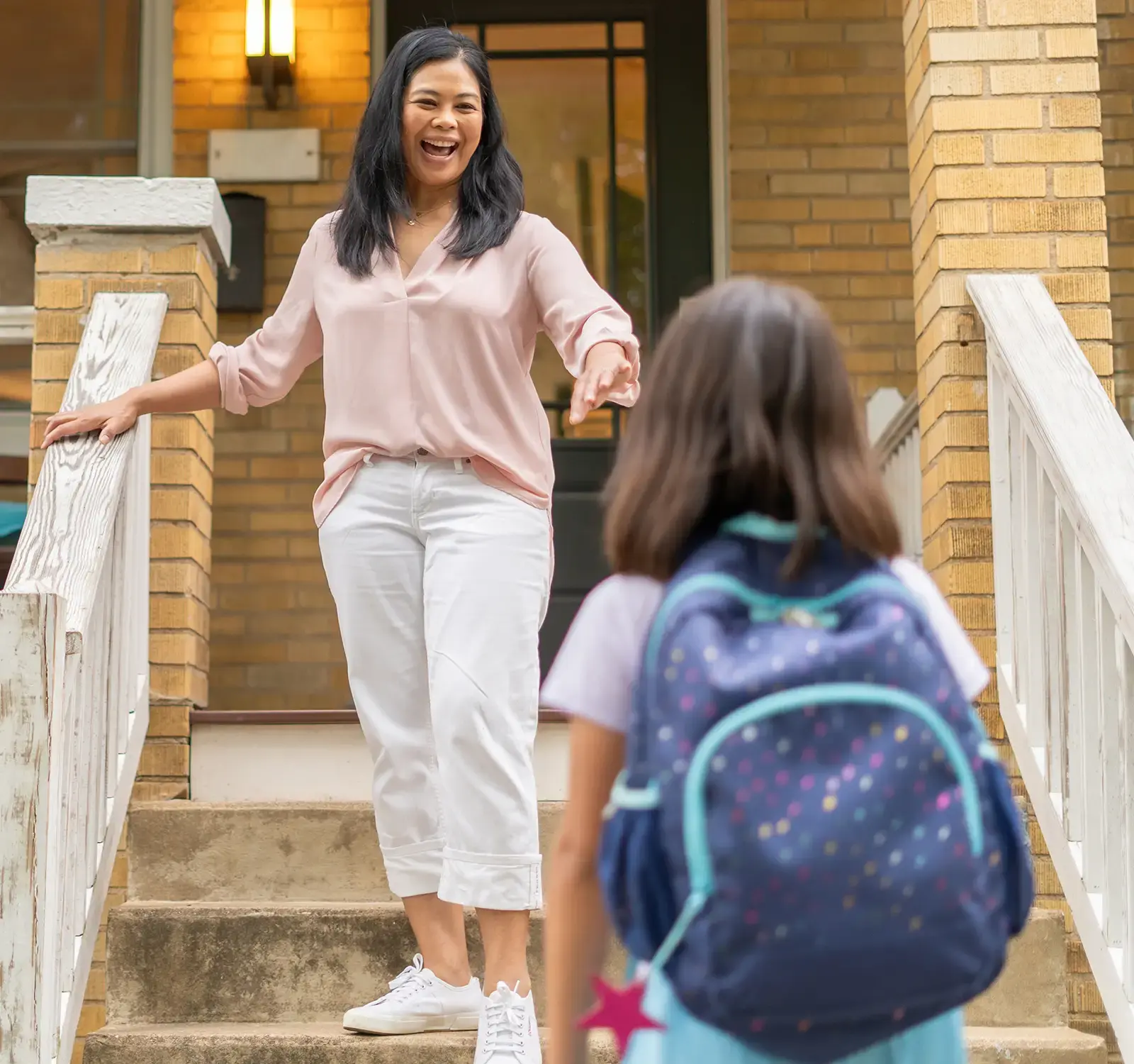 Mom walking down the steps of the porch meeting their child.