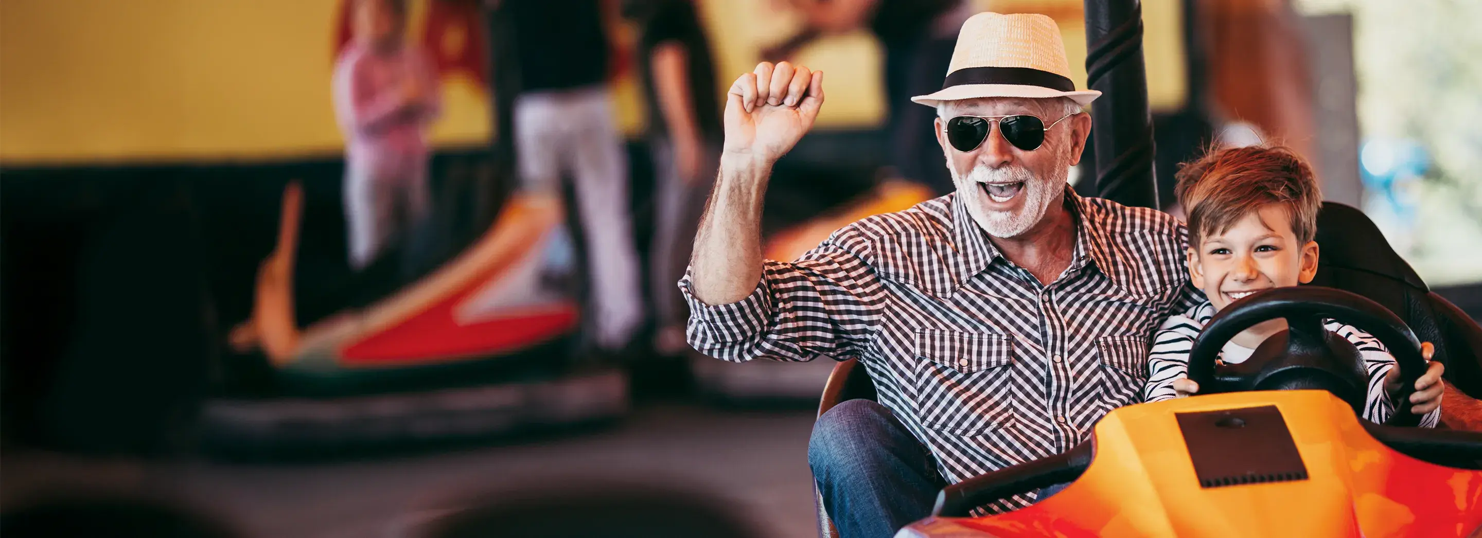 A grandfather and his grandson on a bumper cars ride