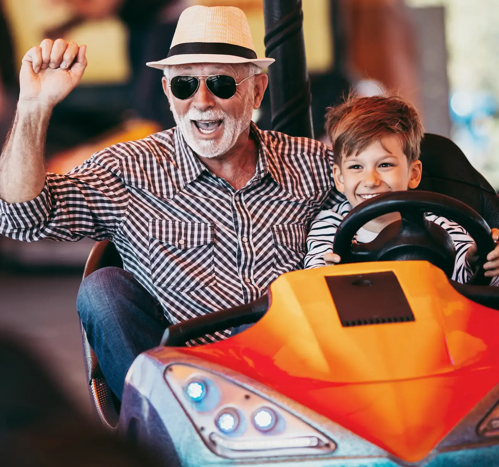 A grandfather and his grandson on a bumper cars ride
