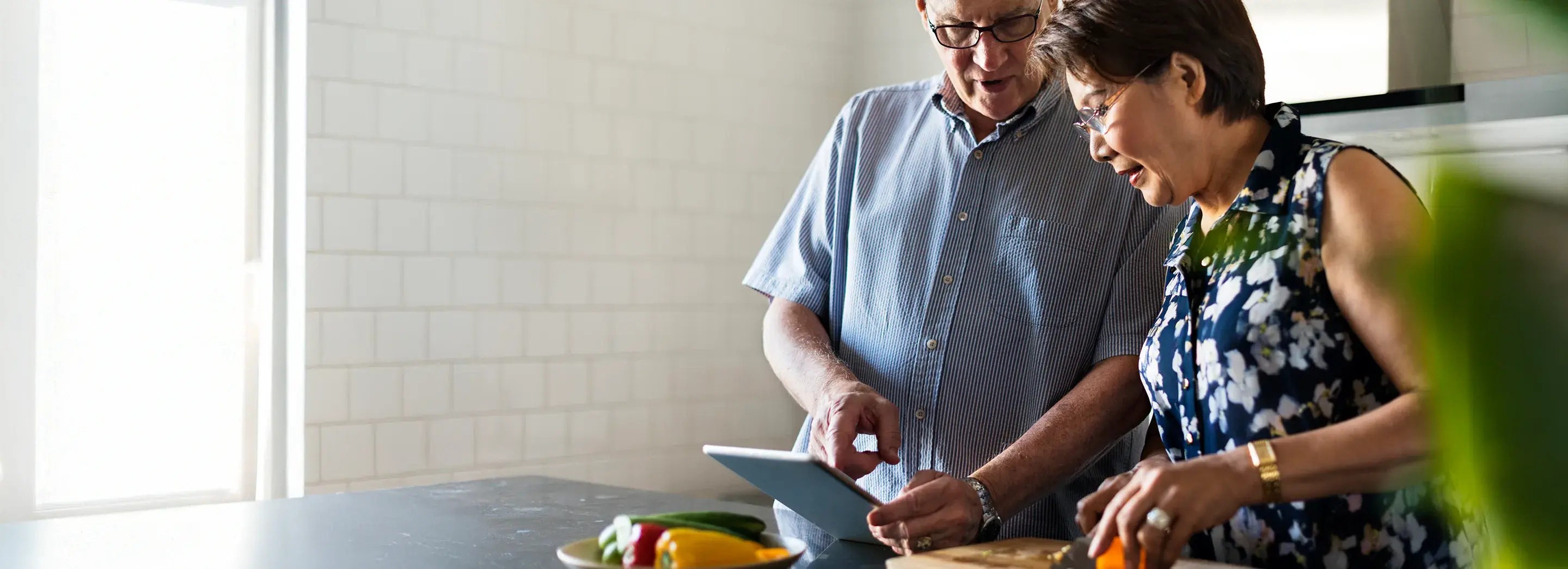 Two People sitting at a table using a computer.