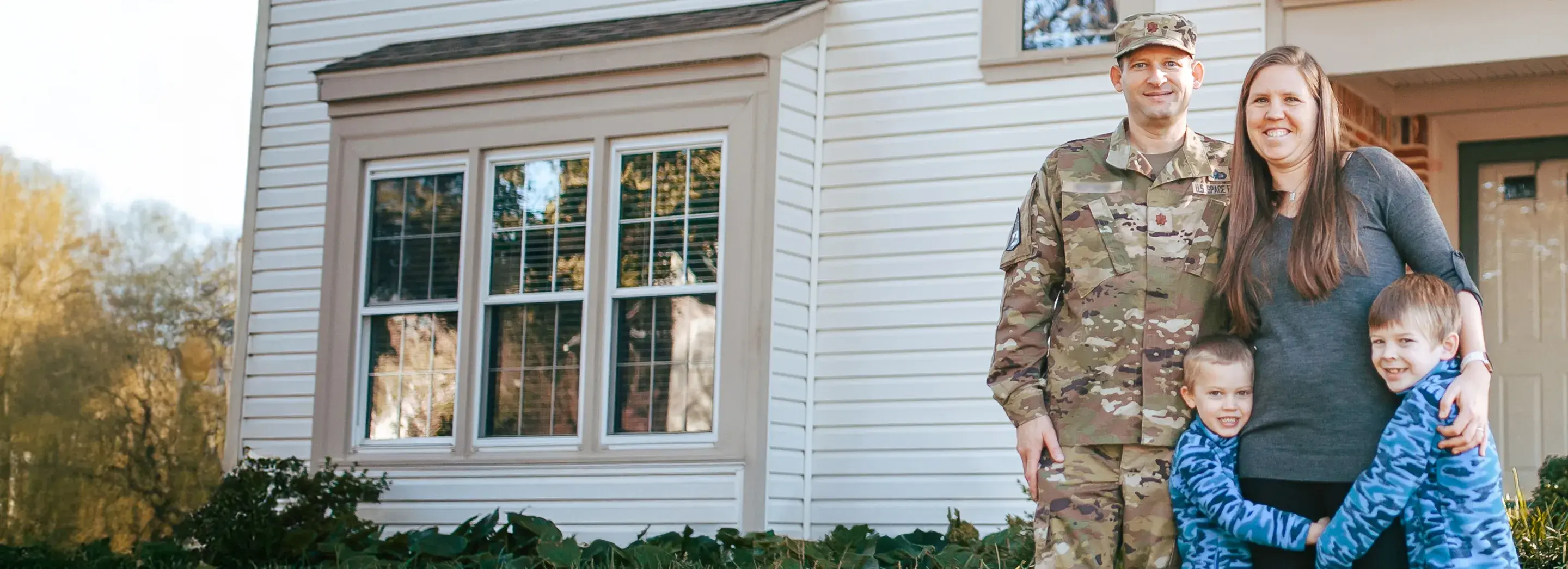 A family posing outside a house.