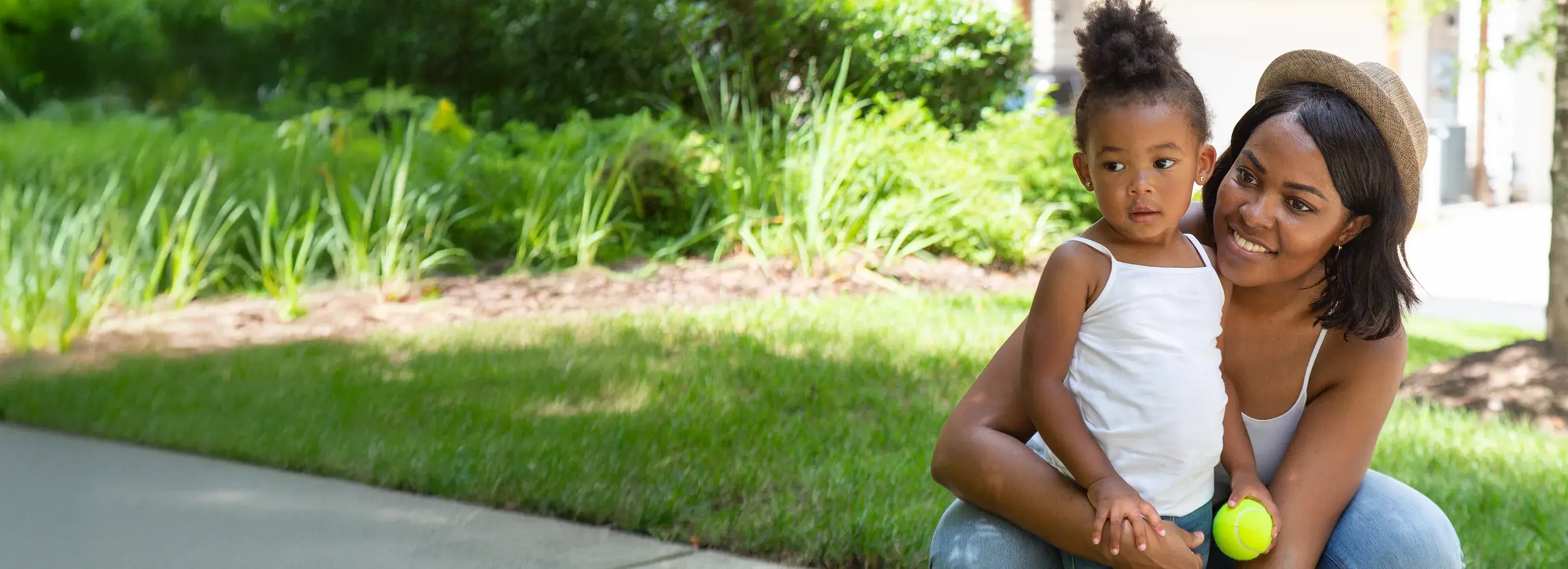 An adult and a child playing outside.