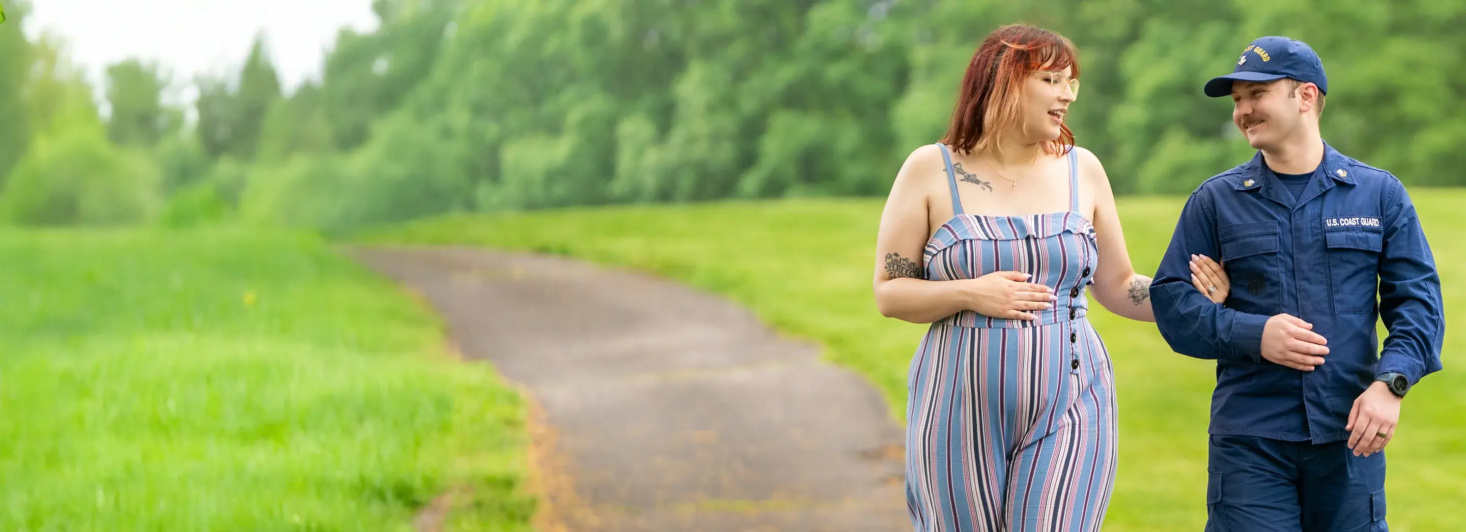 Two people walking in a park arm in arm.