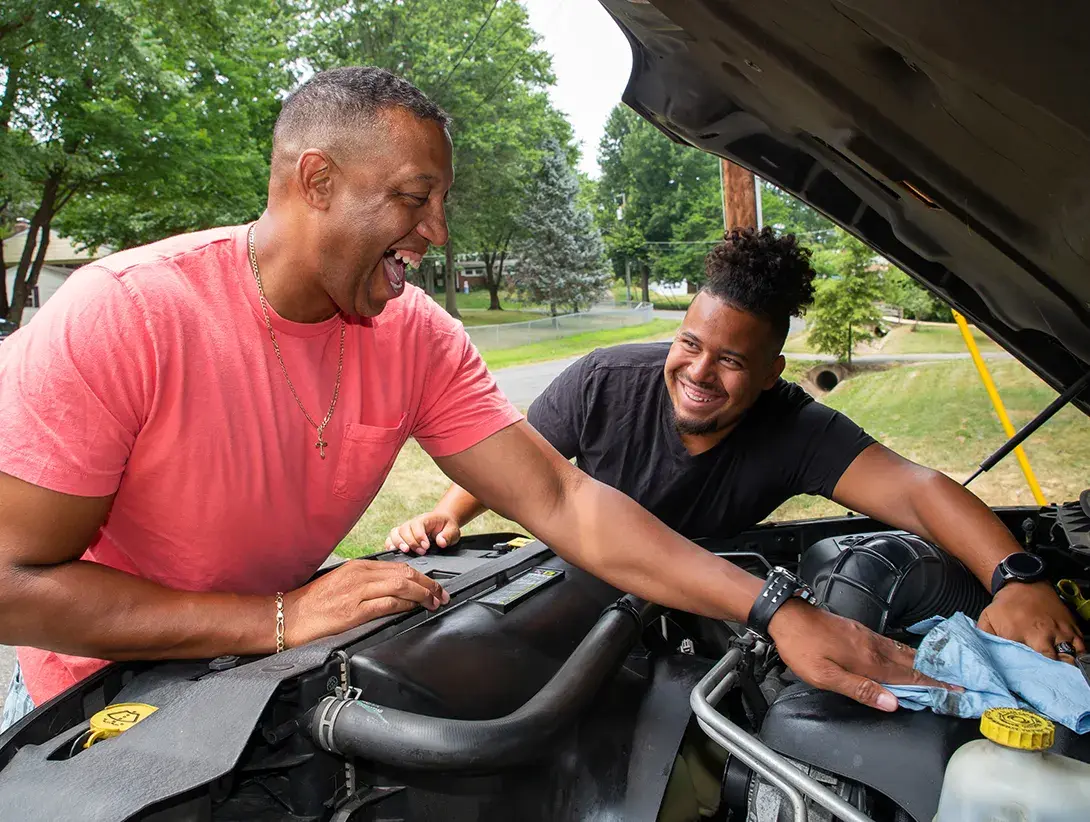 Two people fixing a car.