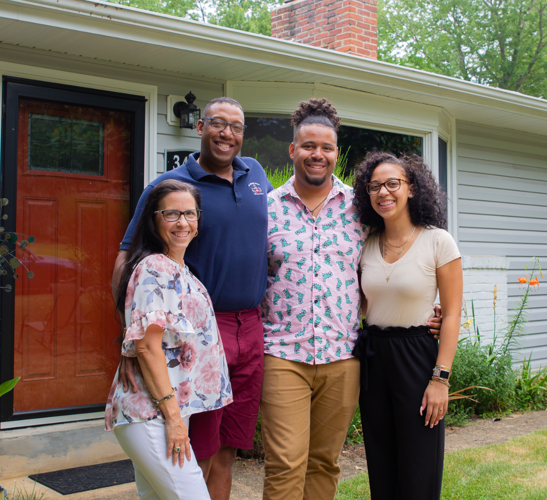 A family posing in front of a house